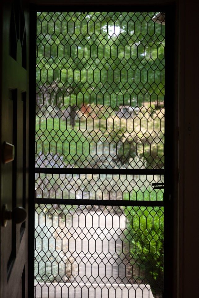 A Window With a Chain Link Fence Behind It and a View of a Garden — Whitsunday Screens & Grilles In Proserpine, QLD