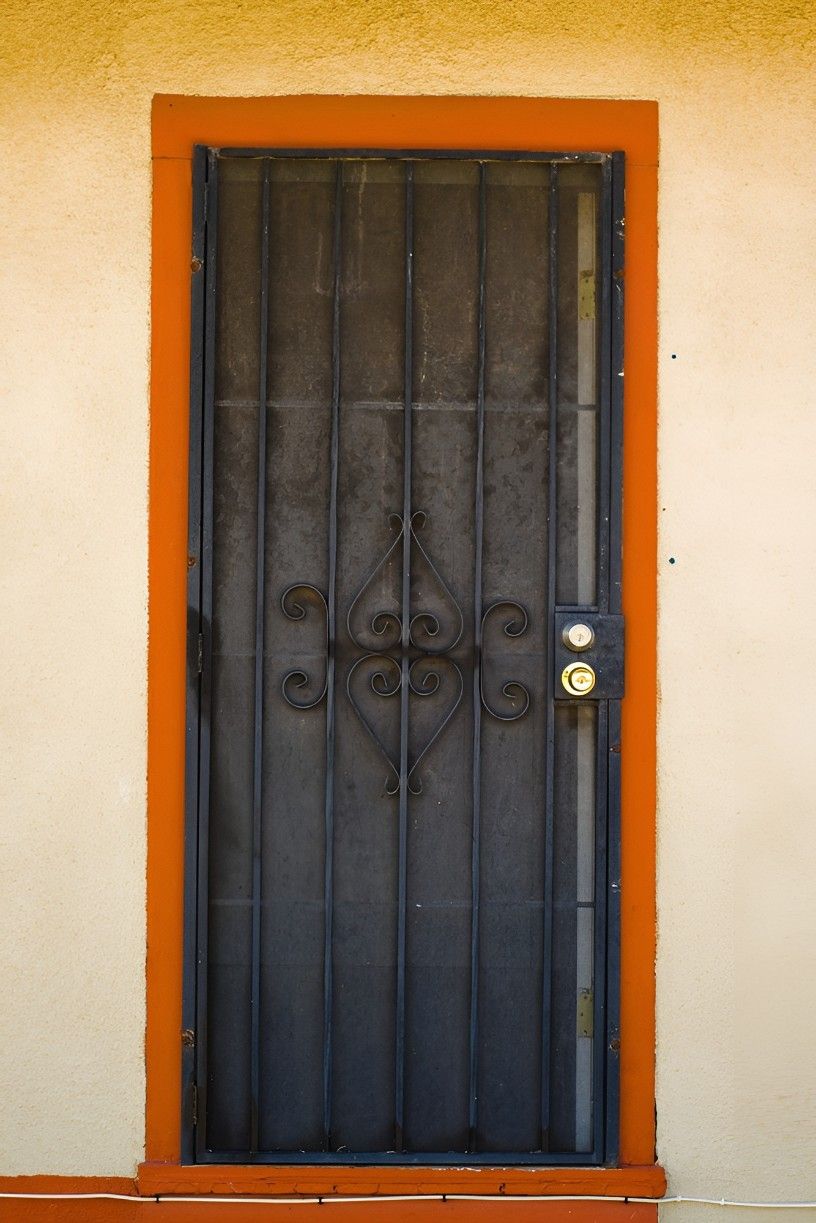 A Black Door With Orange Trim and a Handle — Whitsunday Screens & Grilles In Proserpine, QLD