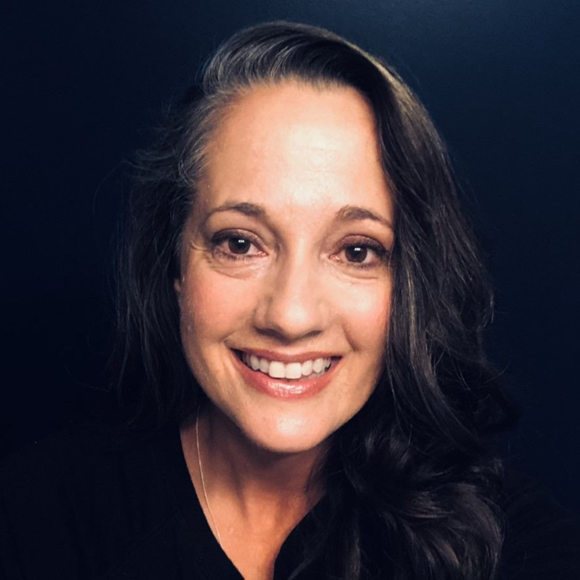 Smiling woman with dark hair, looking at the camera.