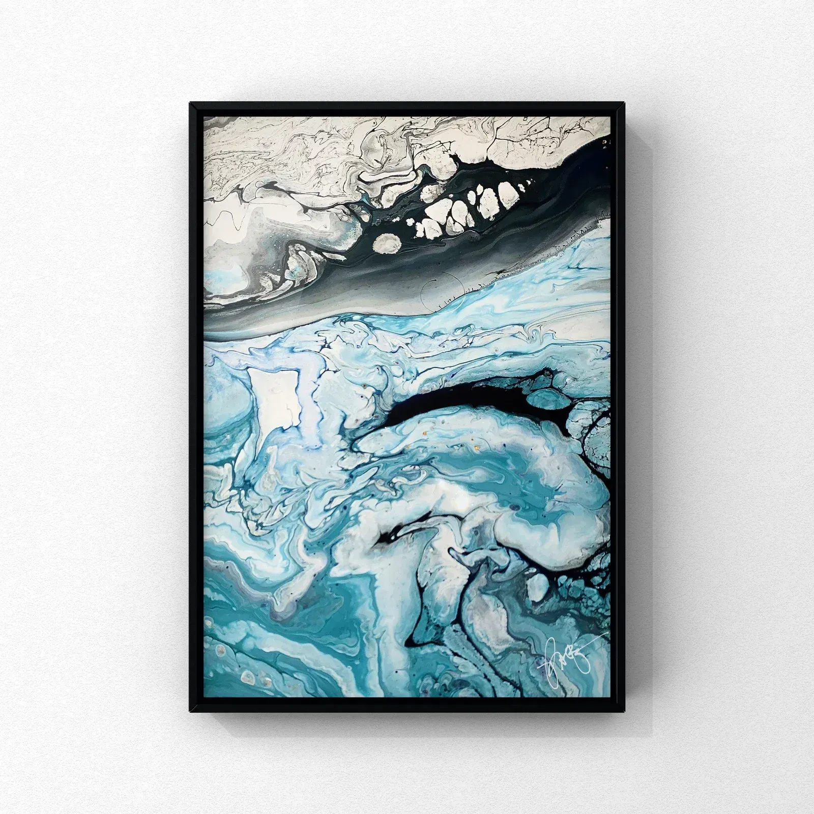 Abstract blue, black, and white marbled artwork in a black frame on a white wall