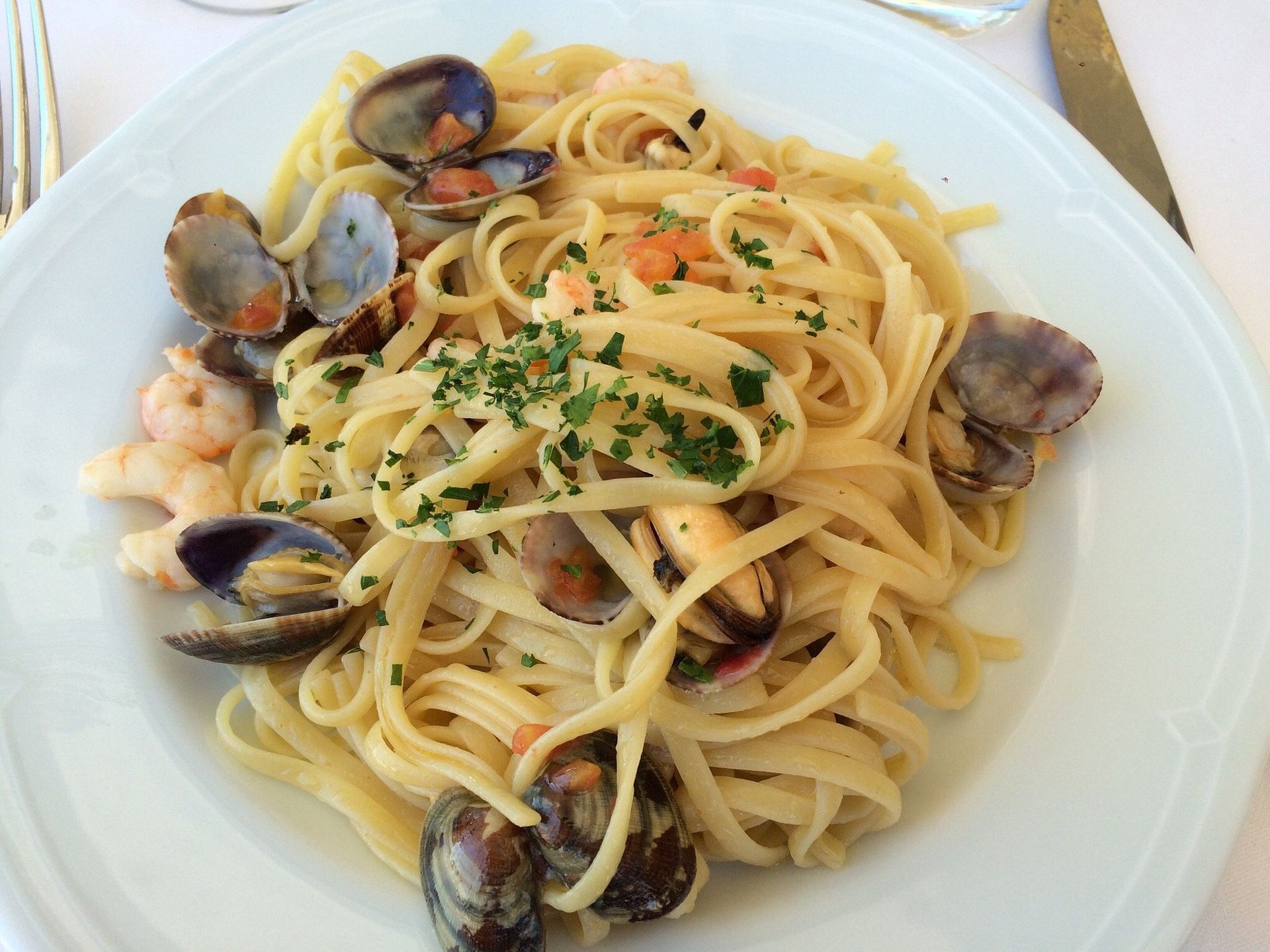 Piatto di linguine con vongole e guarnizione di prezzemolo