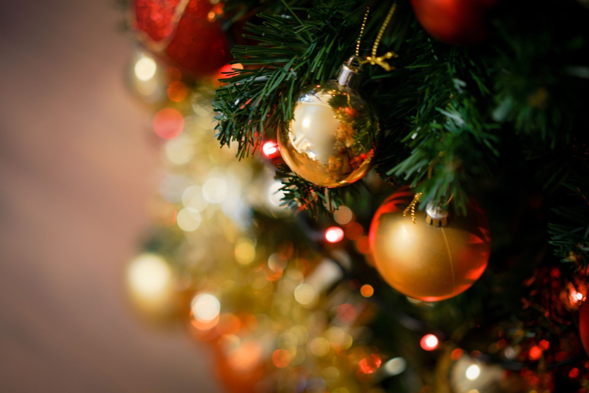 Close-up of a decorated Christmas tree with gold ornaments and warm white lights