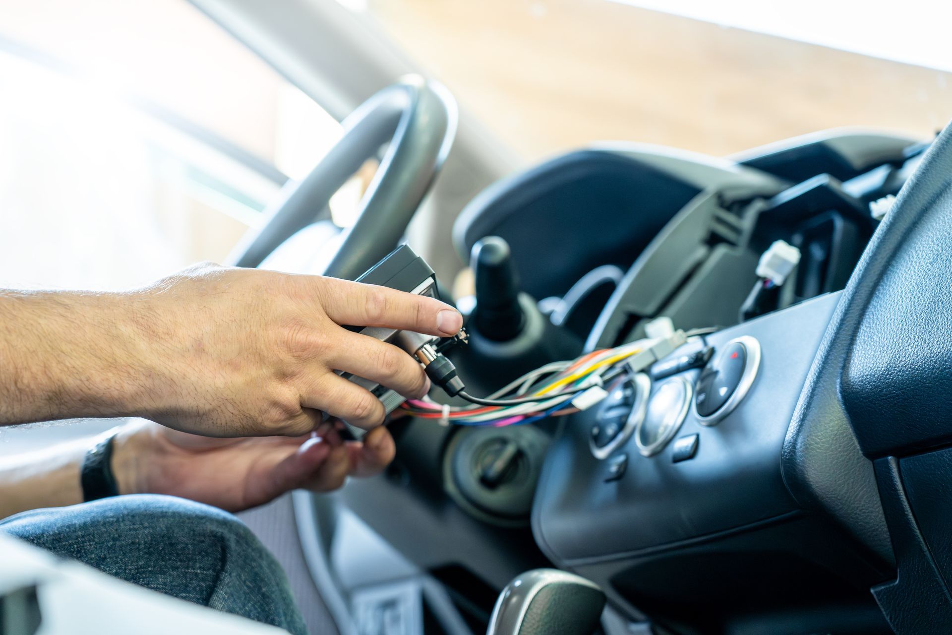 Person installing car stereo, connecting wires in vehicle dashboard. Person installing car stereo, connecting wires in vehicle dashboard.
