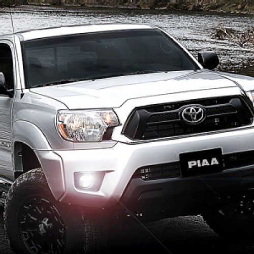 Silver Toyota Tacoma truck with black grill, large tires, and PIAA license plate.