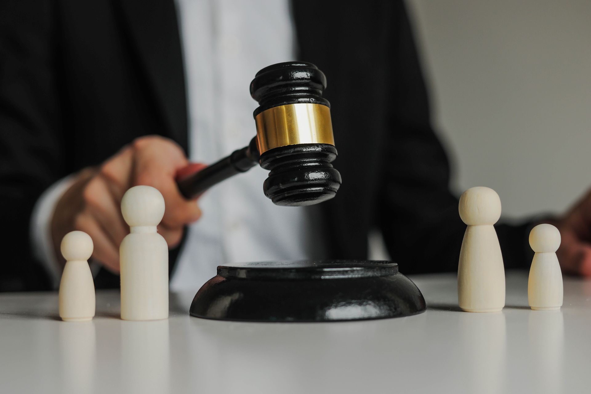 A judge is holding a gavel in front of a group of people.