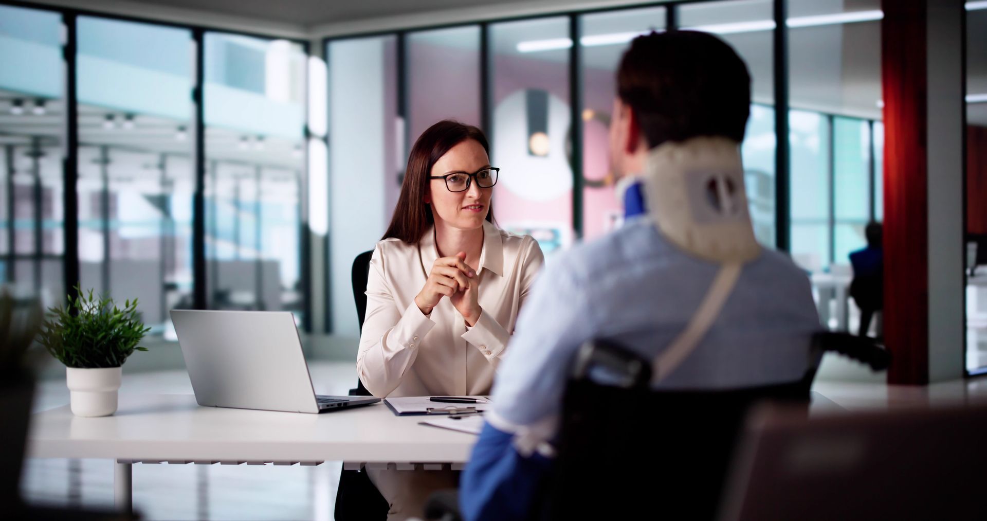 A man in a wheelchair is having a job interview with a woman.