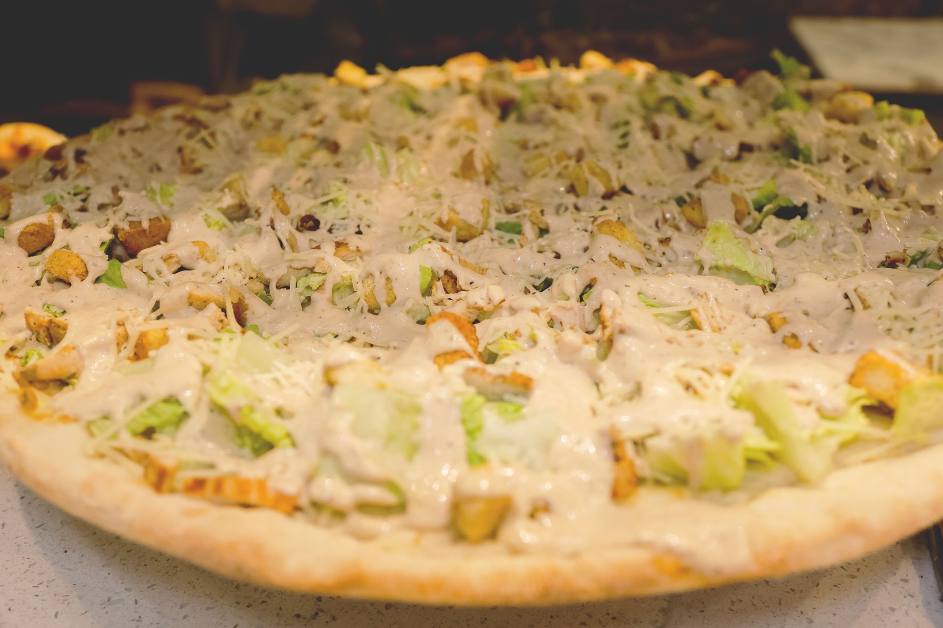 Cheesy vegetable pizza with green peppers and onions on a baking surface