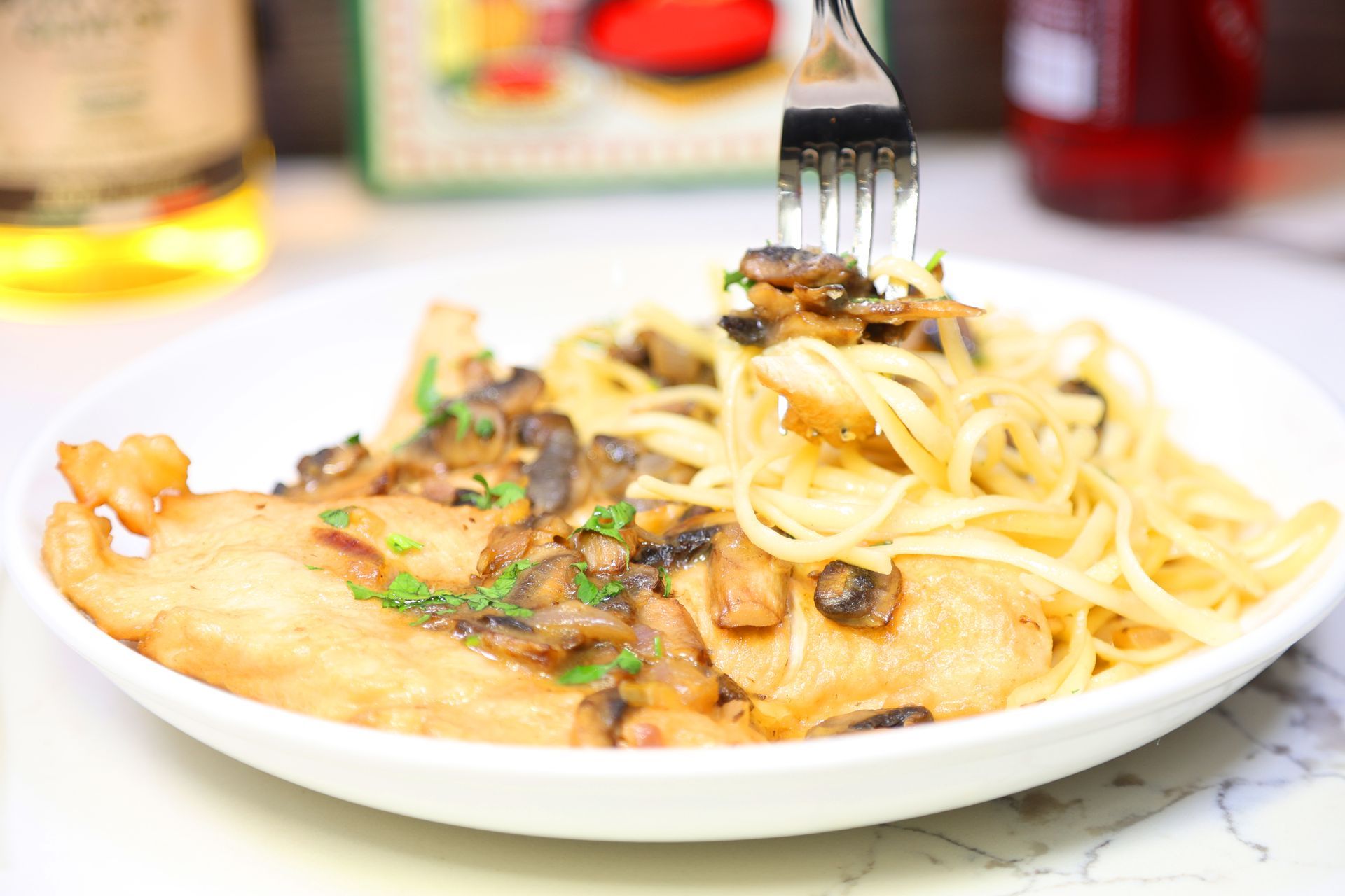 Plate of spaghetti with mushroom cream sauce and shrimp, with a fork lifting pasta