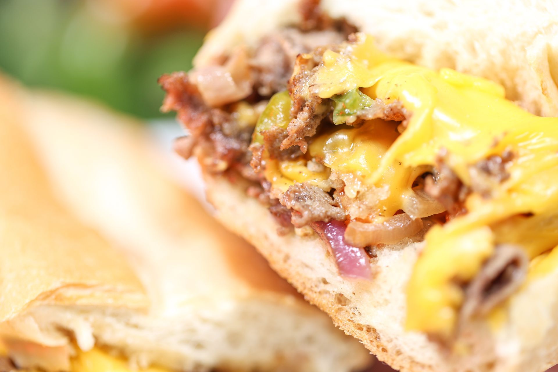 Close-up of a cheeseburger with melted cheese and beef filling on a bun