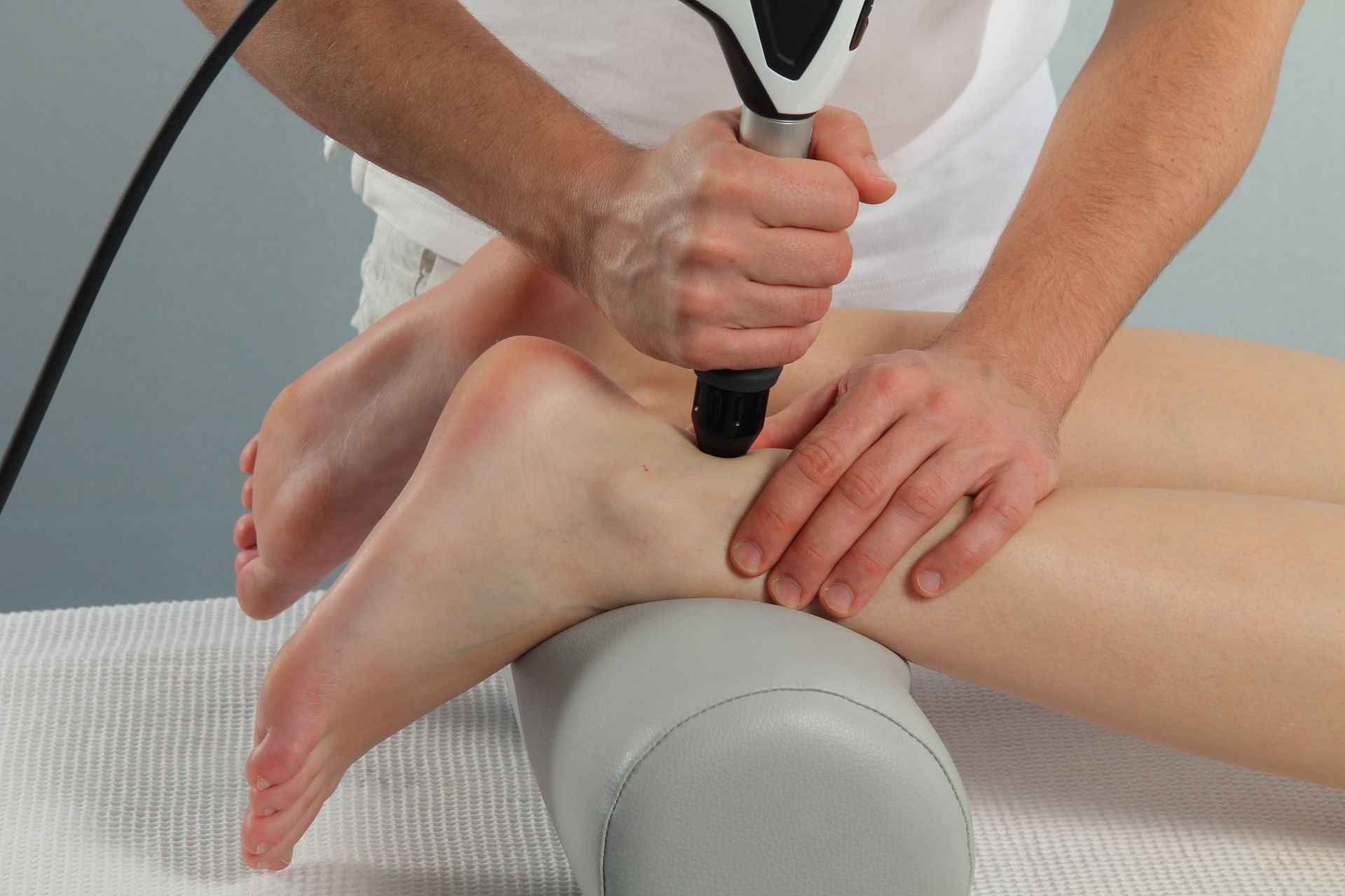 A person is getting a massage on their ankle with a machine.