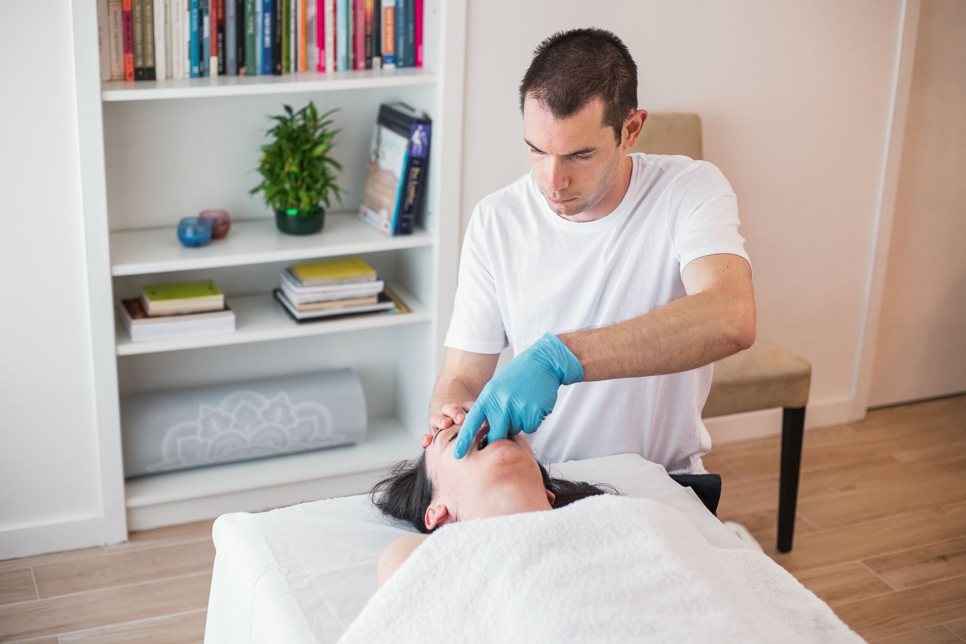 A man is giving a woman a massage on a table.