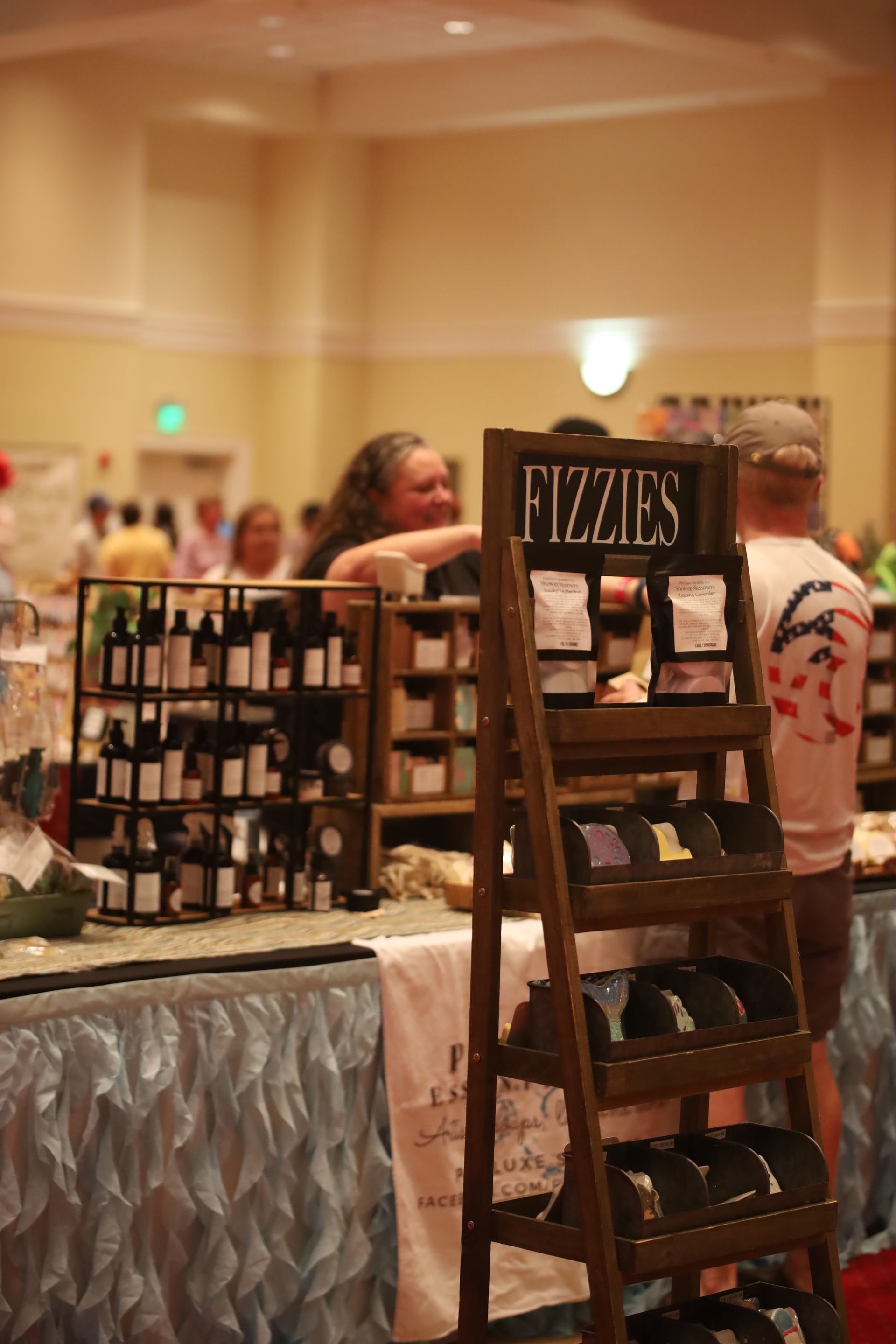 A woman is standing in front of a display of fizzles soap.