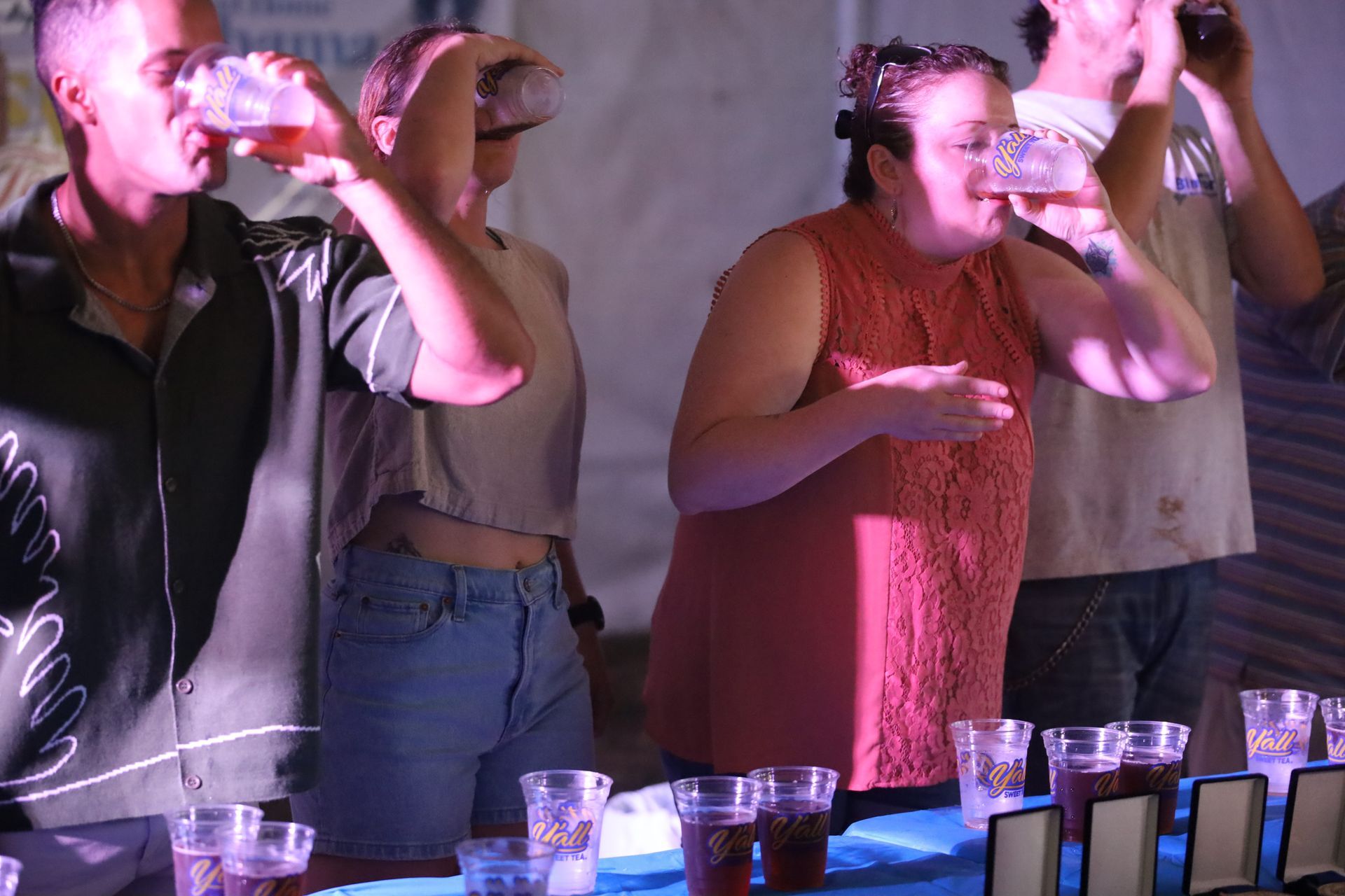 A group of people are drinking beer from plastic cups.