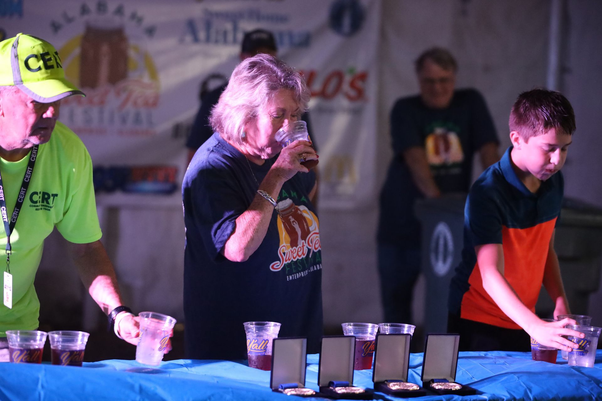 A group of people are standing around a table drinking beer.