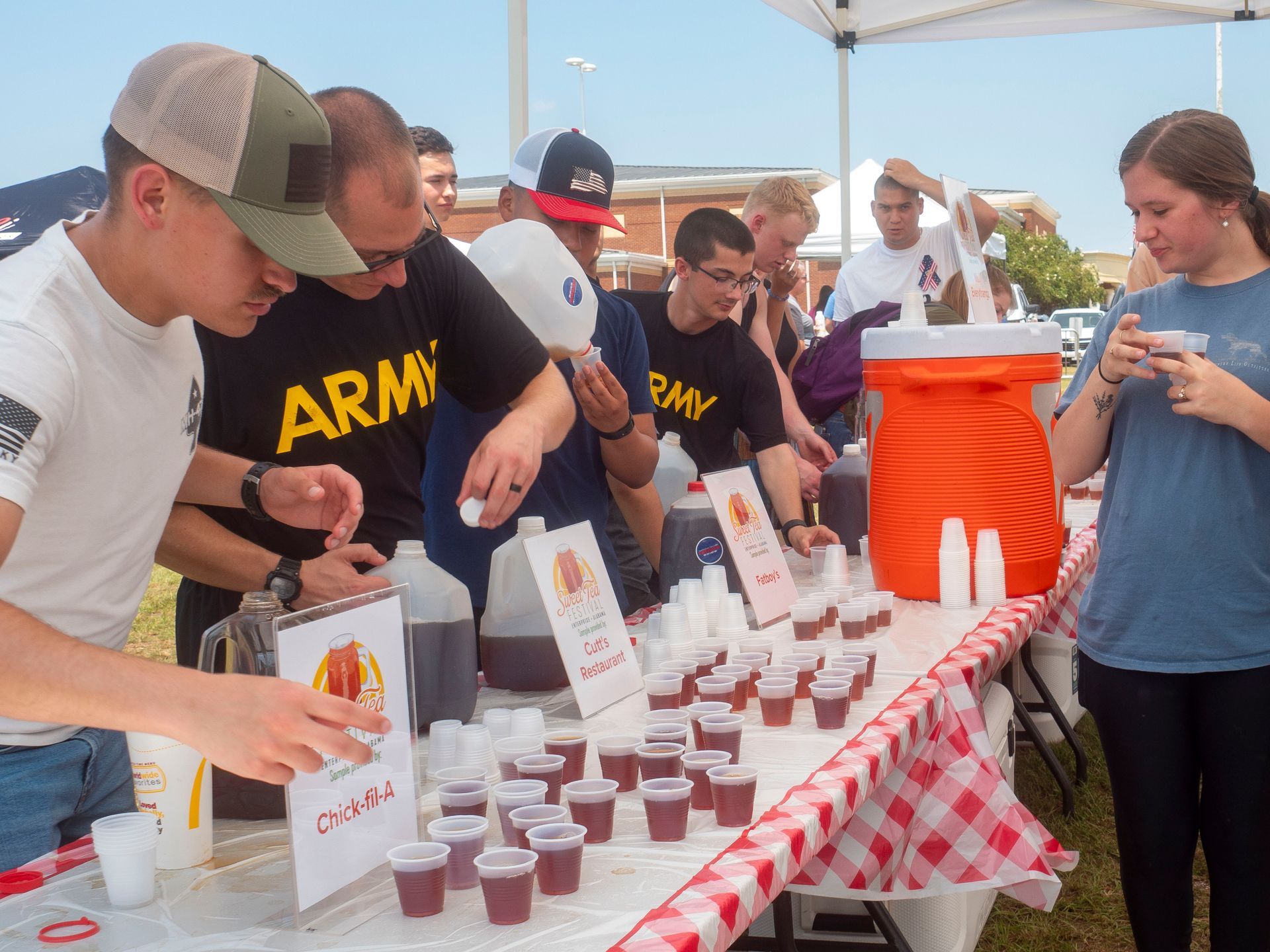 A group of people are standing around a table with a sign that says army on it.