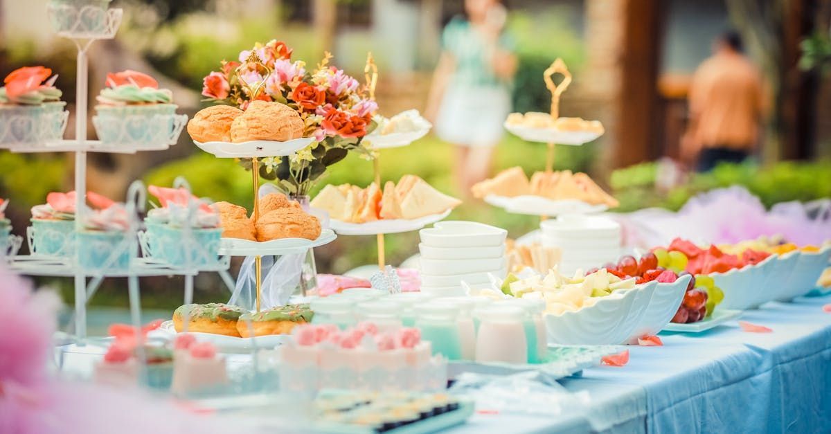 A table topped with a variety of desserts and flowers.