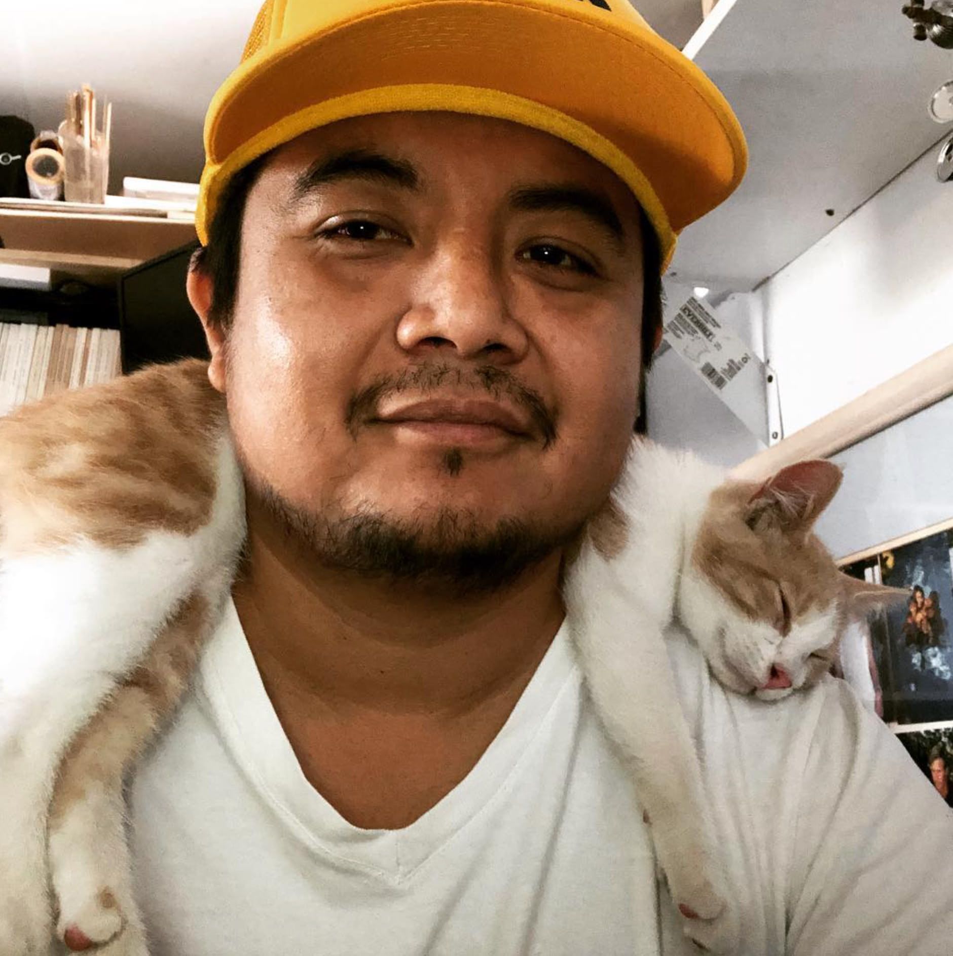 Mario Arellanes of Ryan Levis Architect, Inc., wearing a yellow hat is holding a cat on his shoulder