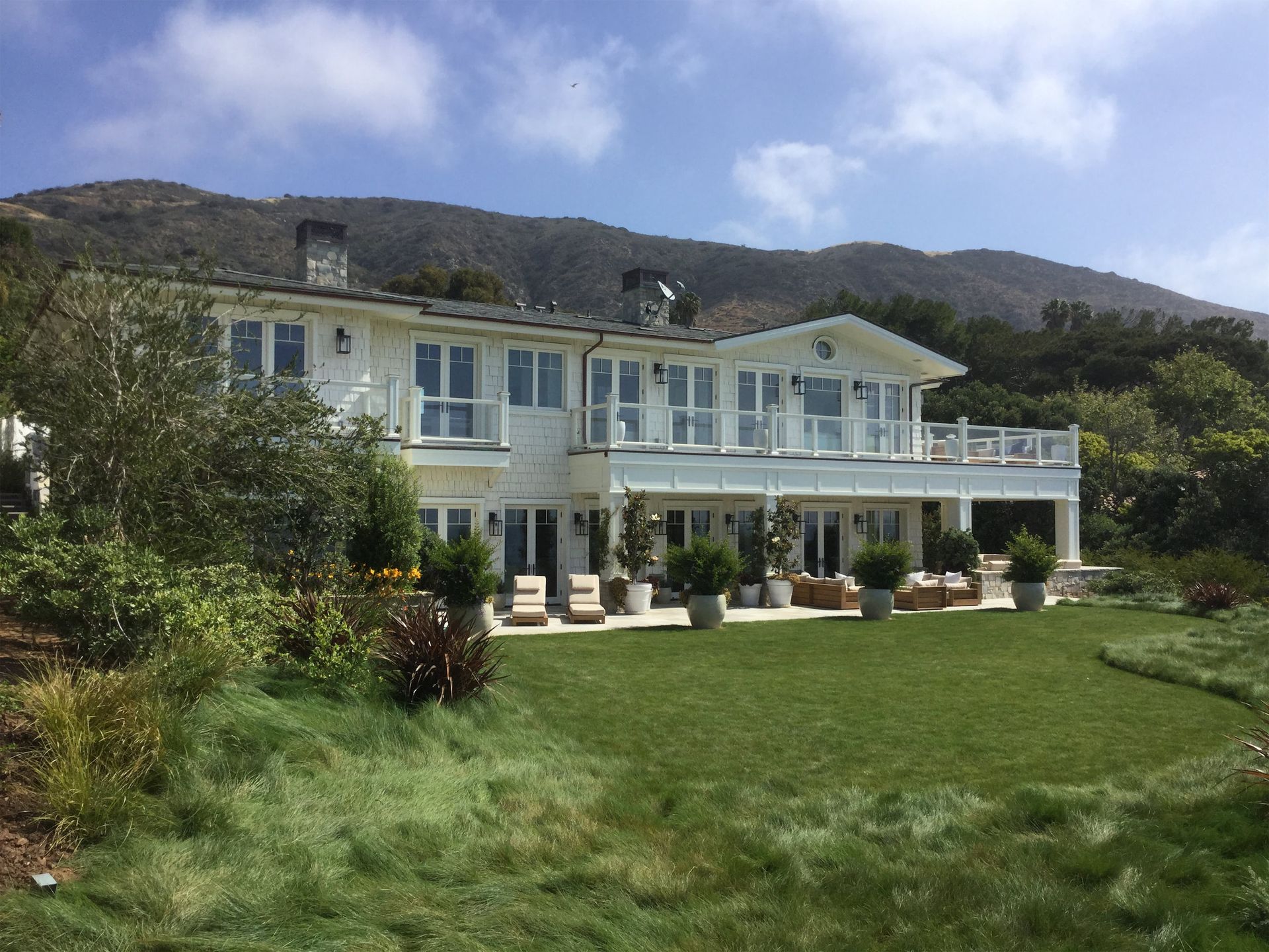 A large white house with a large lawn in front of it