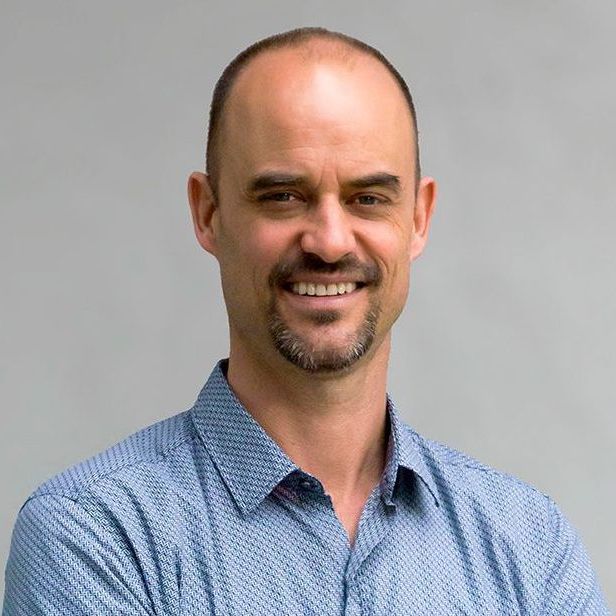 Architect Ryan Levis is smiling for the camera with his arms crossed.