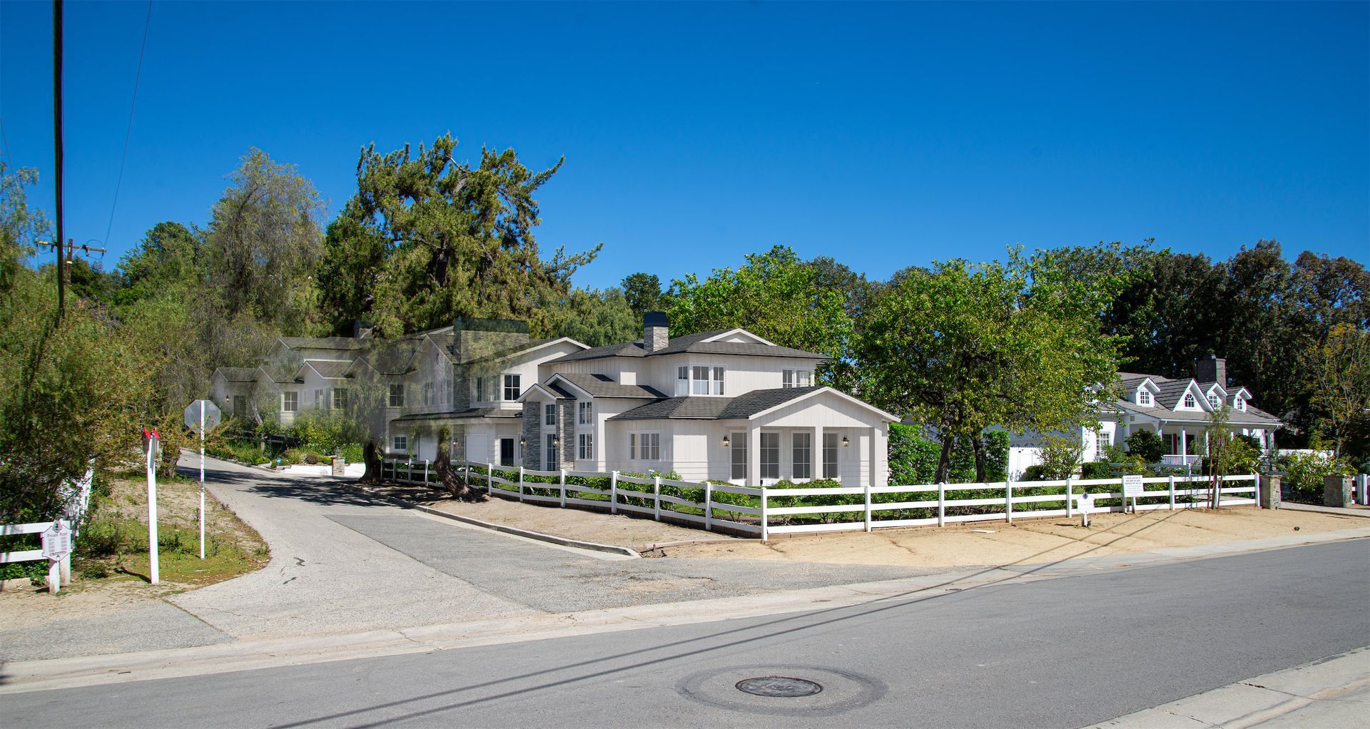 A white house with a fence in front of it