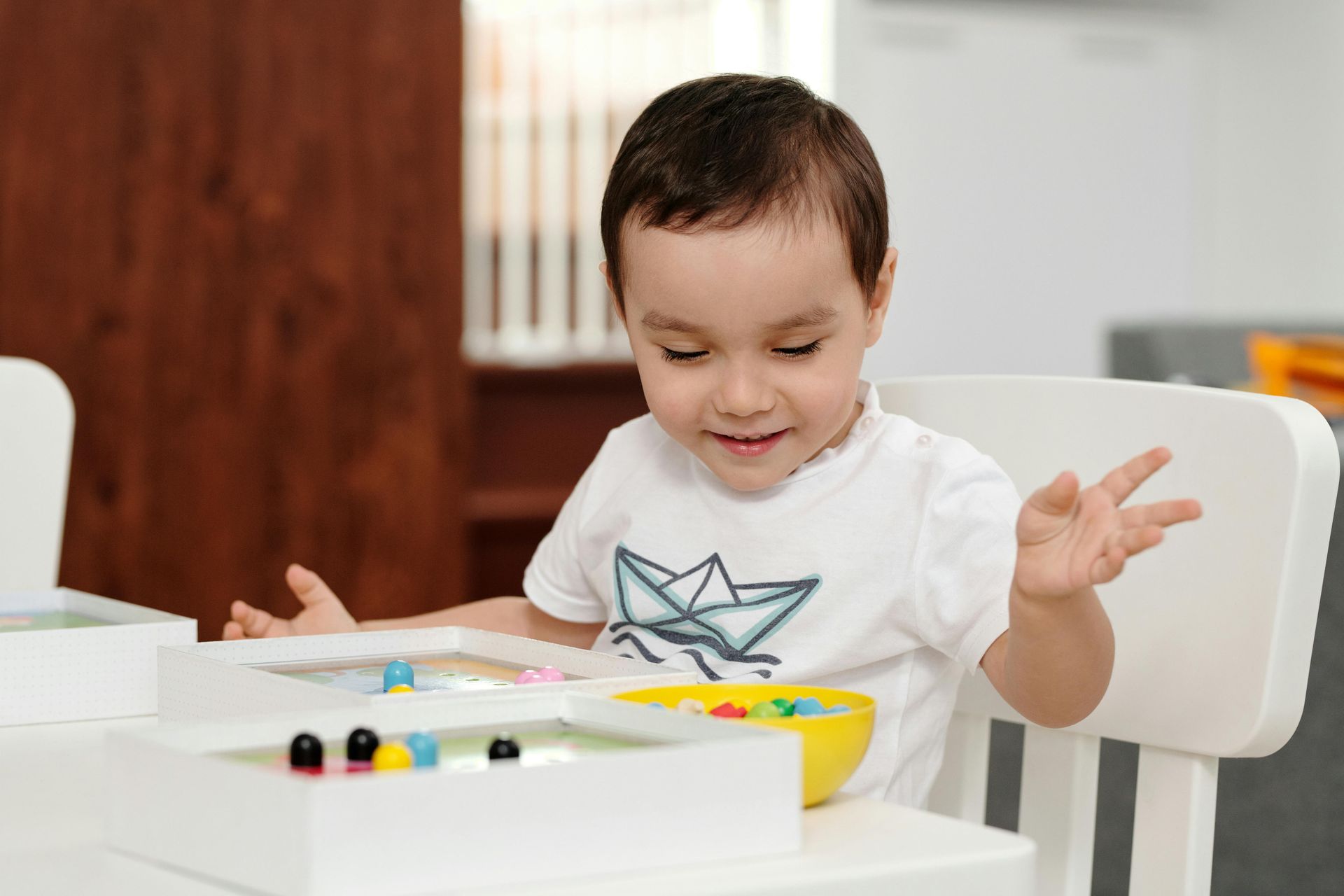 A young boy is playing with a wooden abacus.