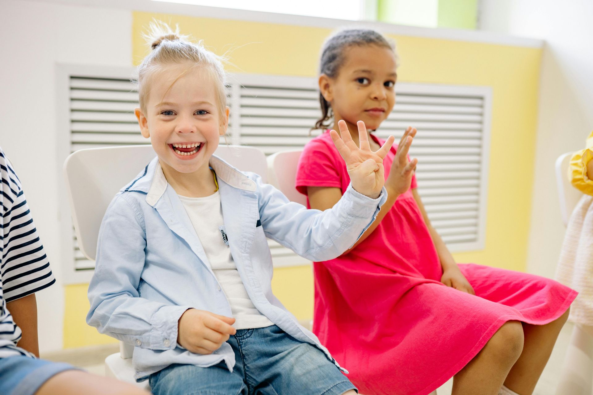 A group of children are sitting at a table eating food.