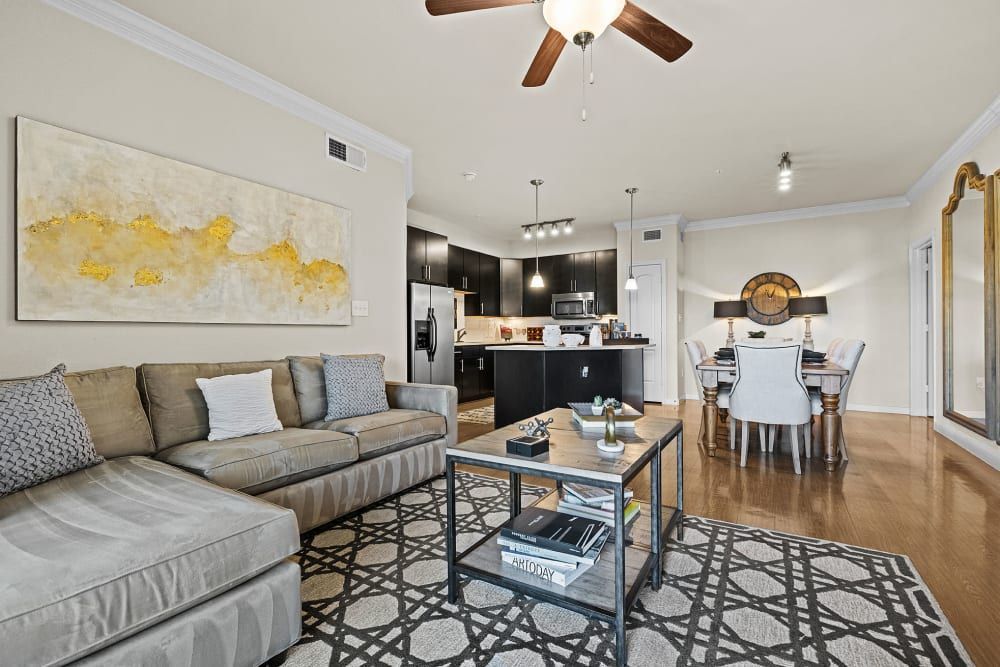 A living room with a couch, coffee table, and ceiling fan at Marquis at the Reserve in Katy, TX.
