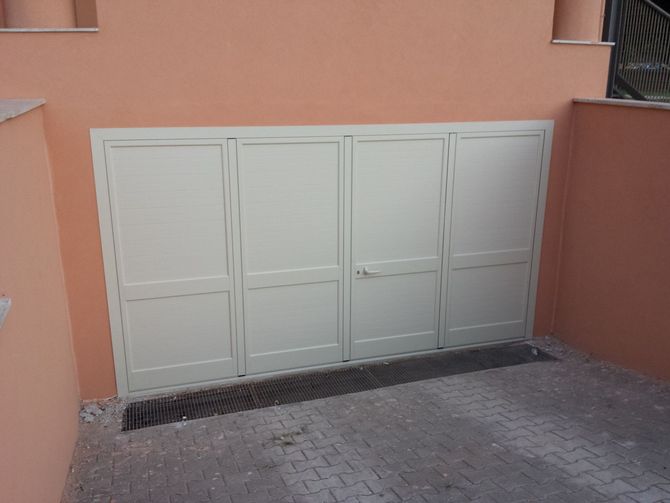 Una porta a vetri incastonata in una cornice di granito nero accanto a una parete rivestita di pannelli di marmo bianco e nero.