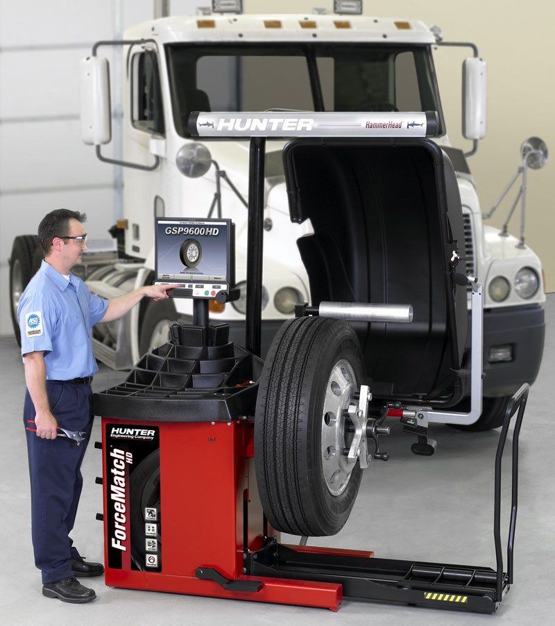 Man Working On Balancing Machine — Columbus, NJ — A1 Auto & Truck Repair Inc Man Working On Balancing Machine — Columbus, NJ — A1 Auto & Truck Repair Inc