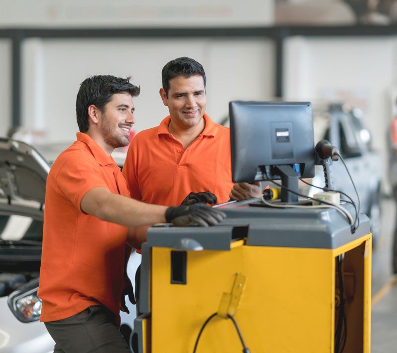 Two mechanics at a computer. Two mechanics at a computer.