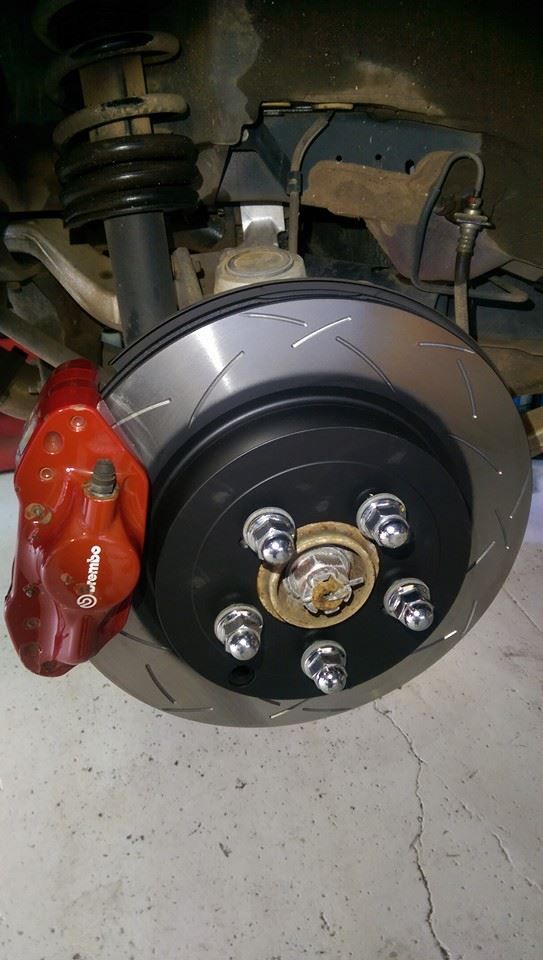A Close Up of a Brake Disc on a Car With a Red Brake Caliper — Northern Service Centre in Westcourt, QLD