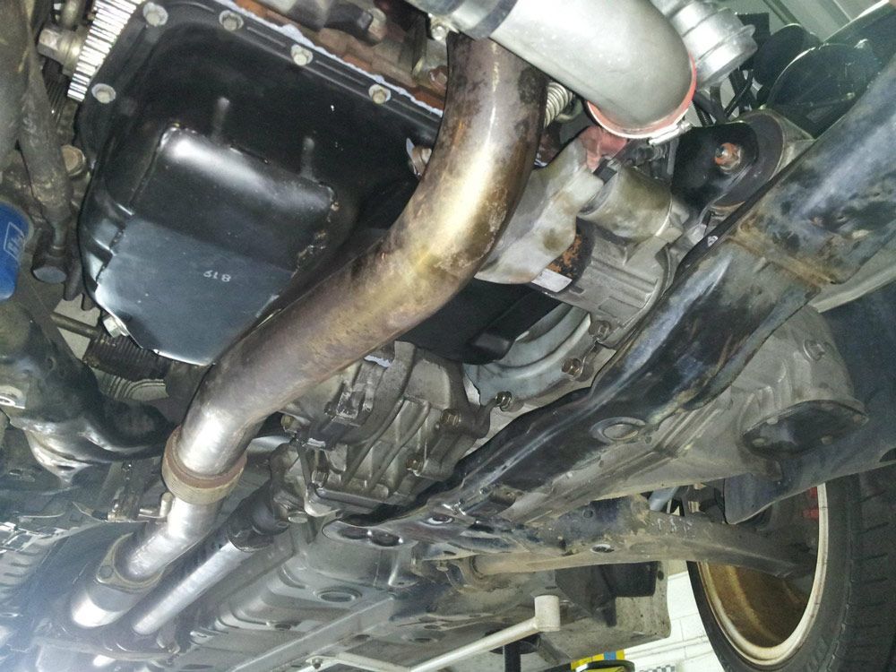 A Close Up of the Underside Exhaust Pipe on a Car — Northern Service Centre in Westcourt, QLD