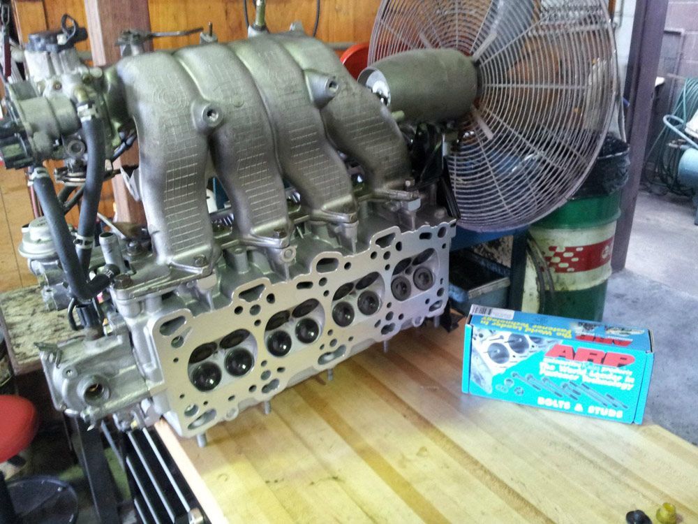A Car Engine is Sitting on a Wooden Table Next to a Fan — Northern Service Centre in Westcourt, QLD