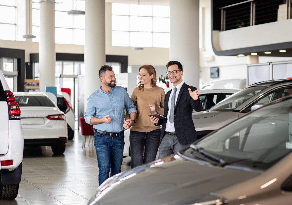 A Group of People Are Standing in A Car Showroom Looking at Cars — Start Learning Automotive in Brisbane, QLD