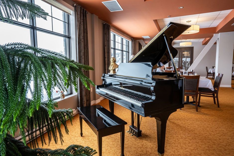 Un piano à queue est placé dans une pièce à côté d'un banc.