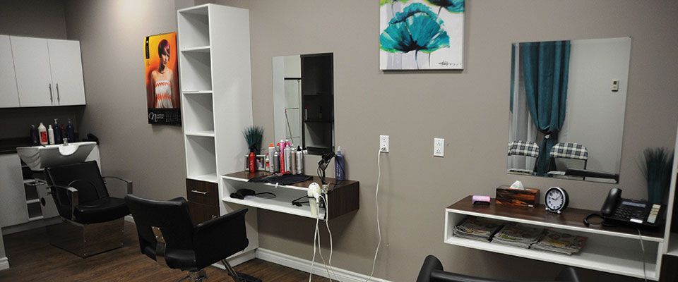 Un salon de coiffure avec deux chaises, un lavabo et un miroir.
