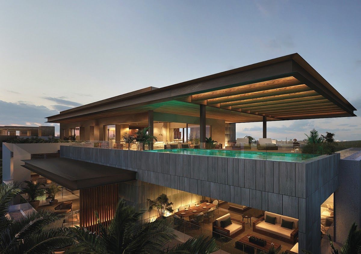 Modern luxury house at dusk with a large cantilevered roof and warm interior lights