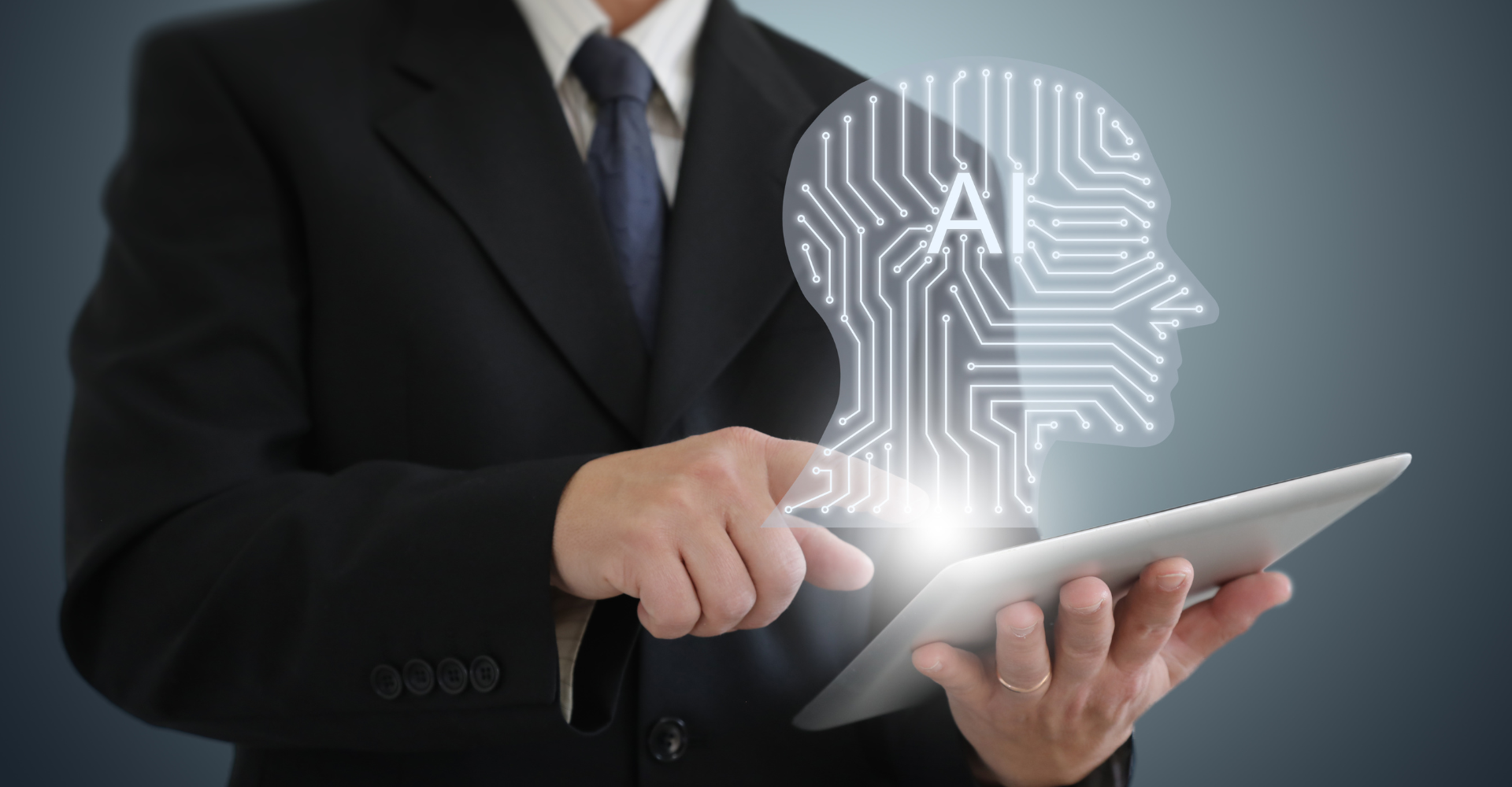 A person in a suit interacts with a tablet, projecting a glowing digital head with circuit patterns and