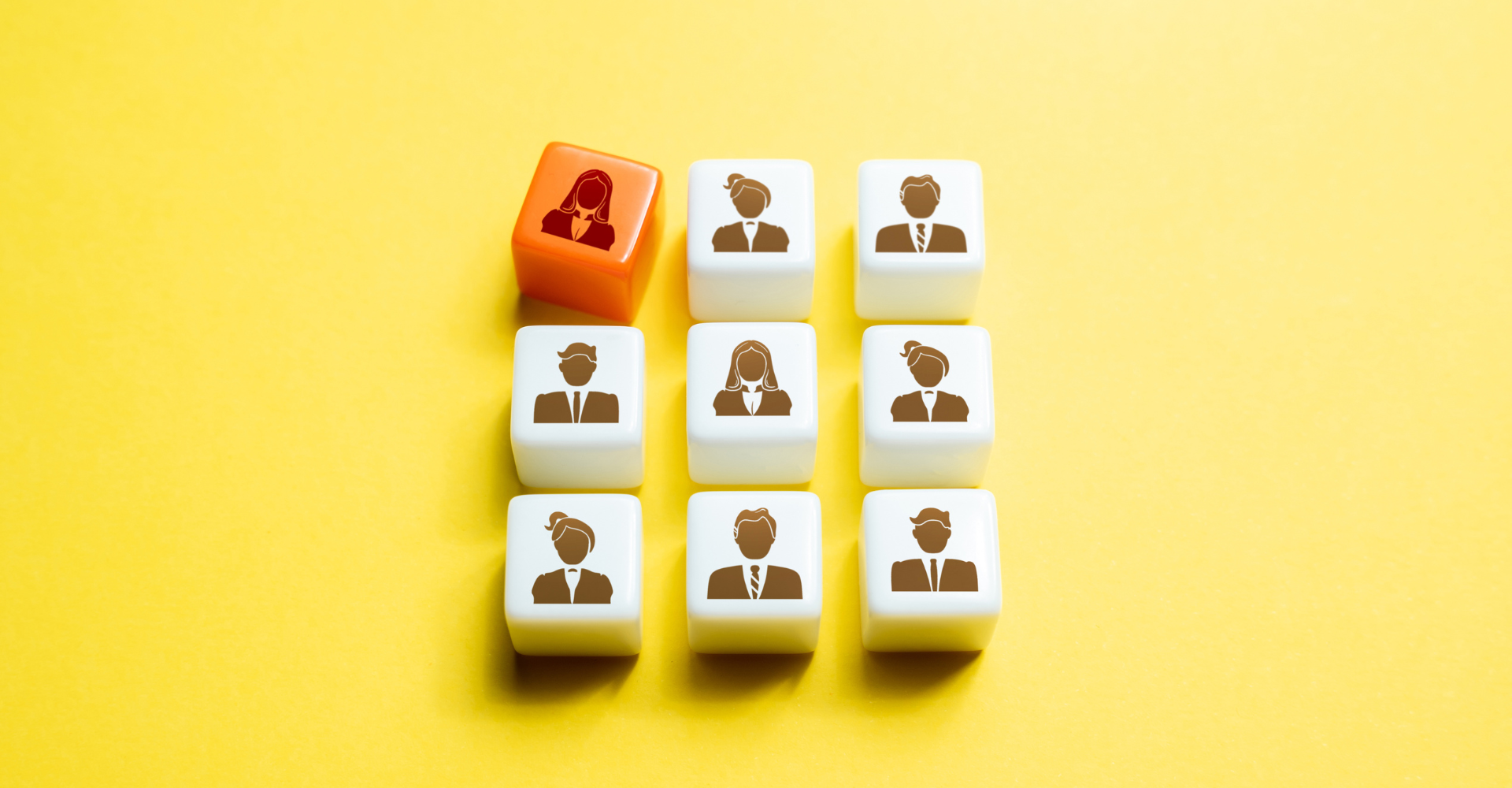 Nine cubes displaying silhouettes of people. One cube is orange, highlighting a female figure.