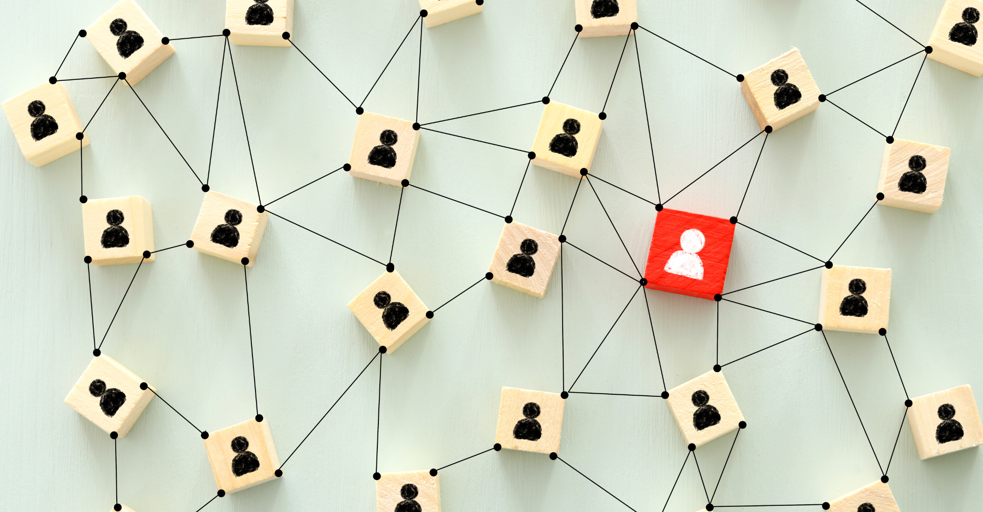 Wooden tiles with user icons connected by lines, forming a network on a light background. One central red tile stands out.