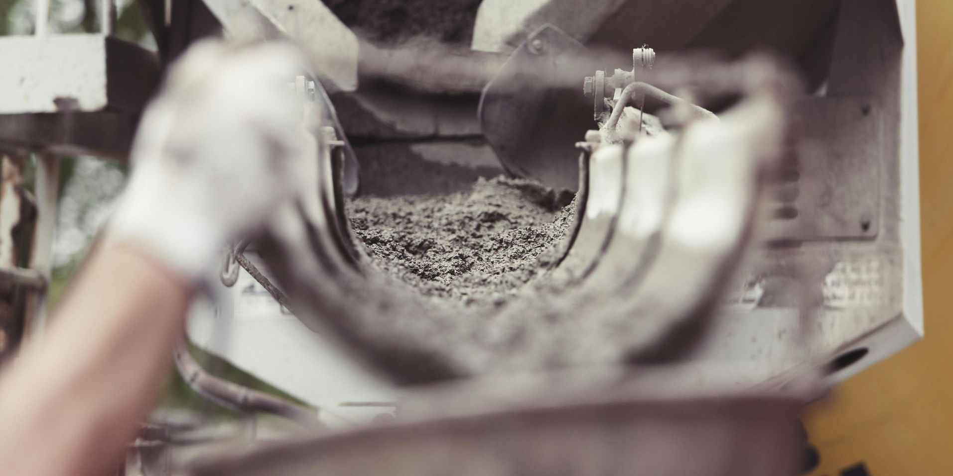 A person is pouring concrete into a commercial site.