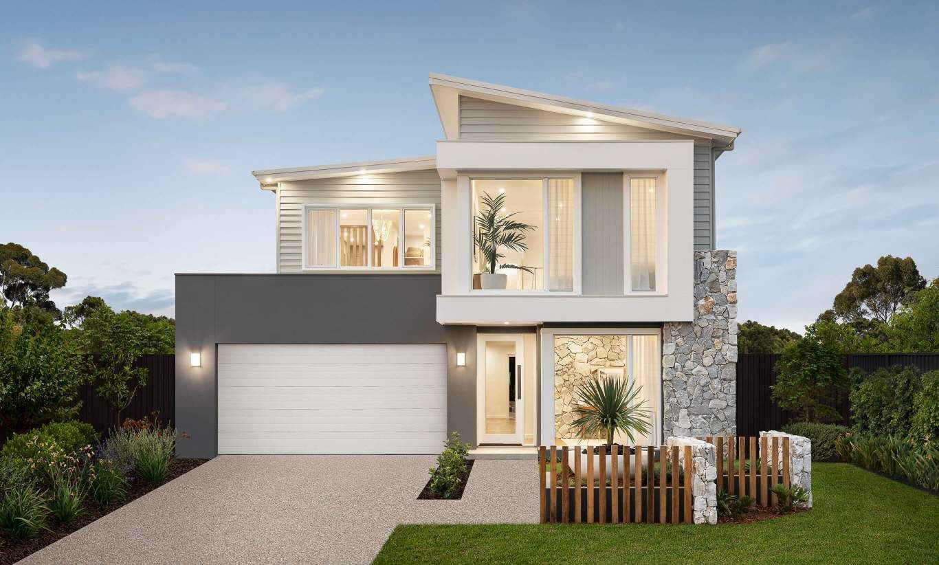 Modern two-story house with gray, white, and stone facade, driveway, small fence, and landscaping.