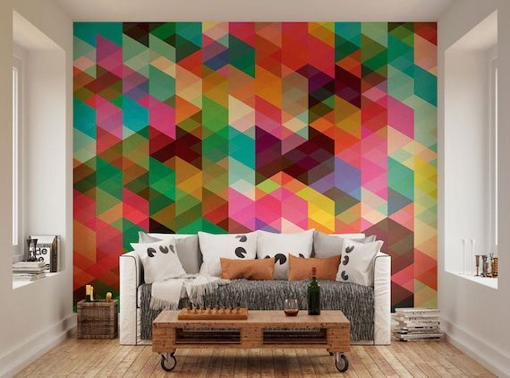 Living room with colorful geometric wall art. White sofa, wooden coffee table, and light wood floor.