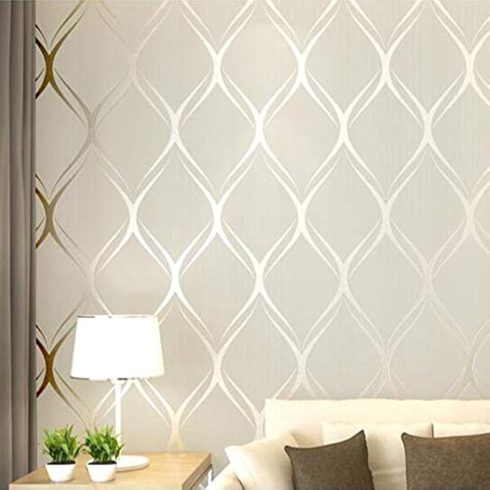 Beige wallpaper with a repeating, curved diamond pattern; lamp, plants, and pillows.