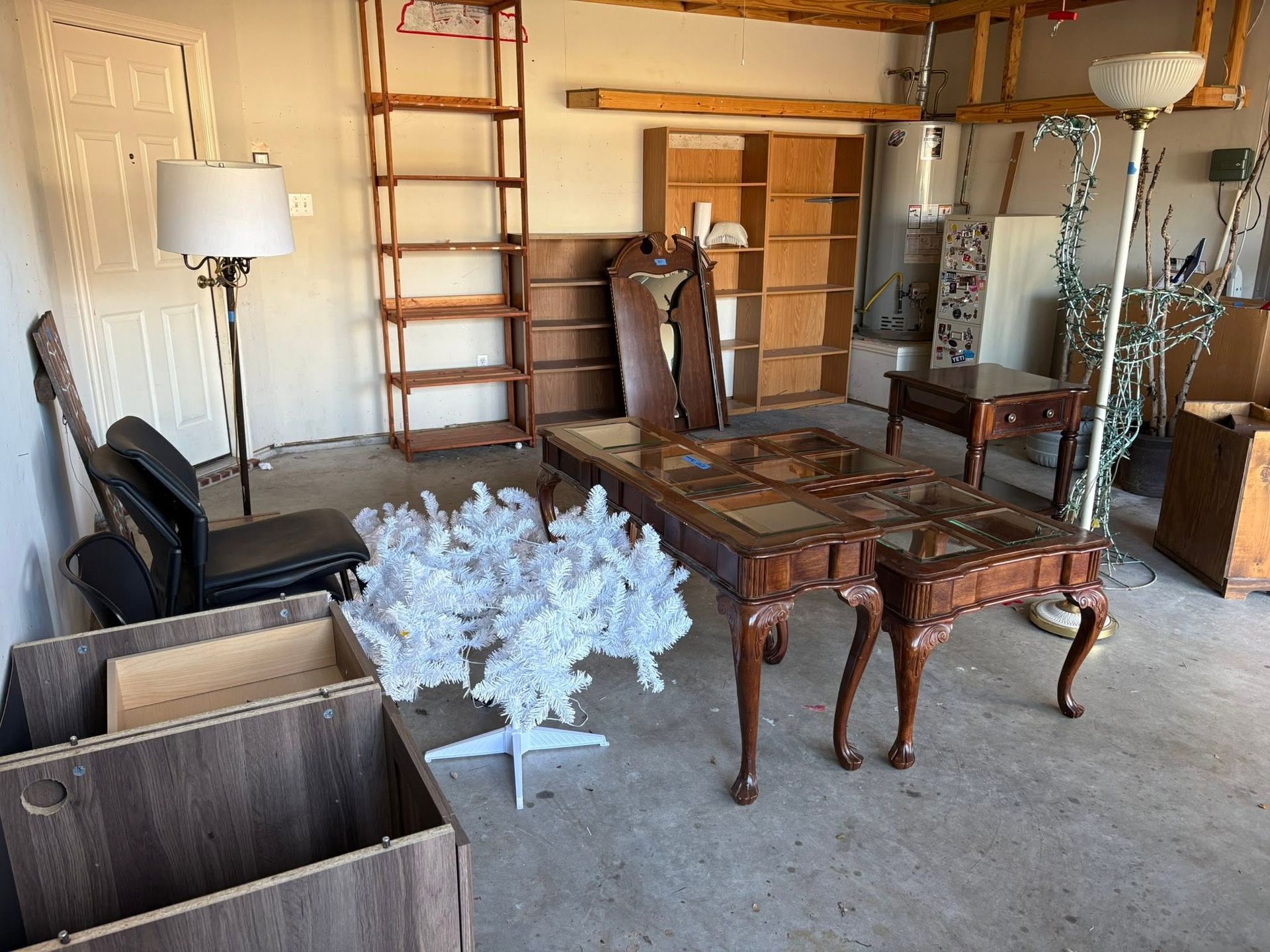A cluttered room with wooden furniture, a white coral decoration, and a ladder against the wall.