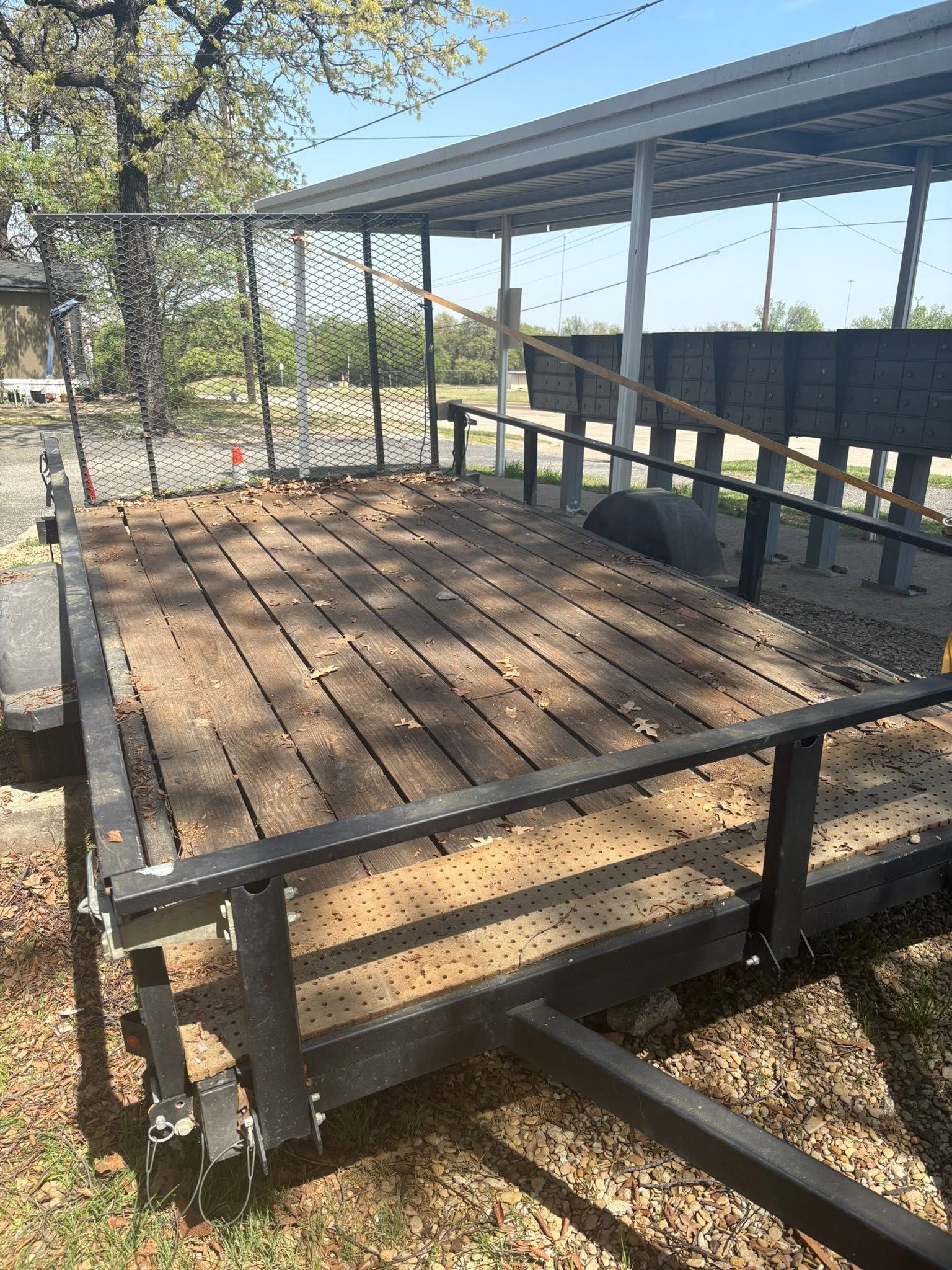 Covered wooden porch with a ramp, metal railing, and steps leading up to a house
