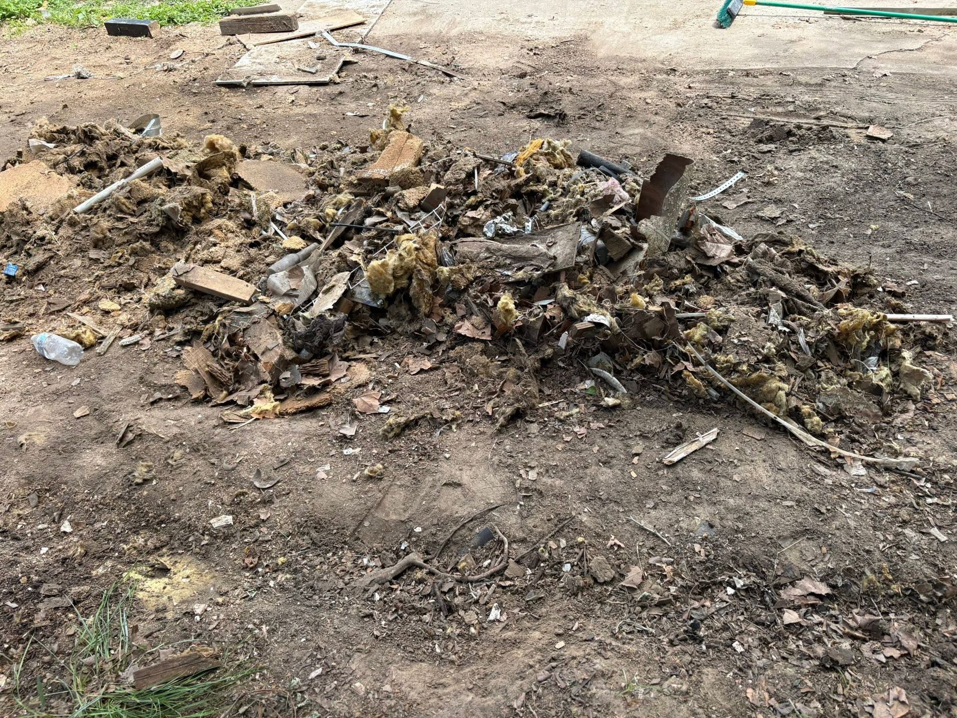 Charred debris and ash scattered on bare ground at an outdoor site