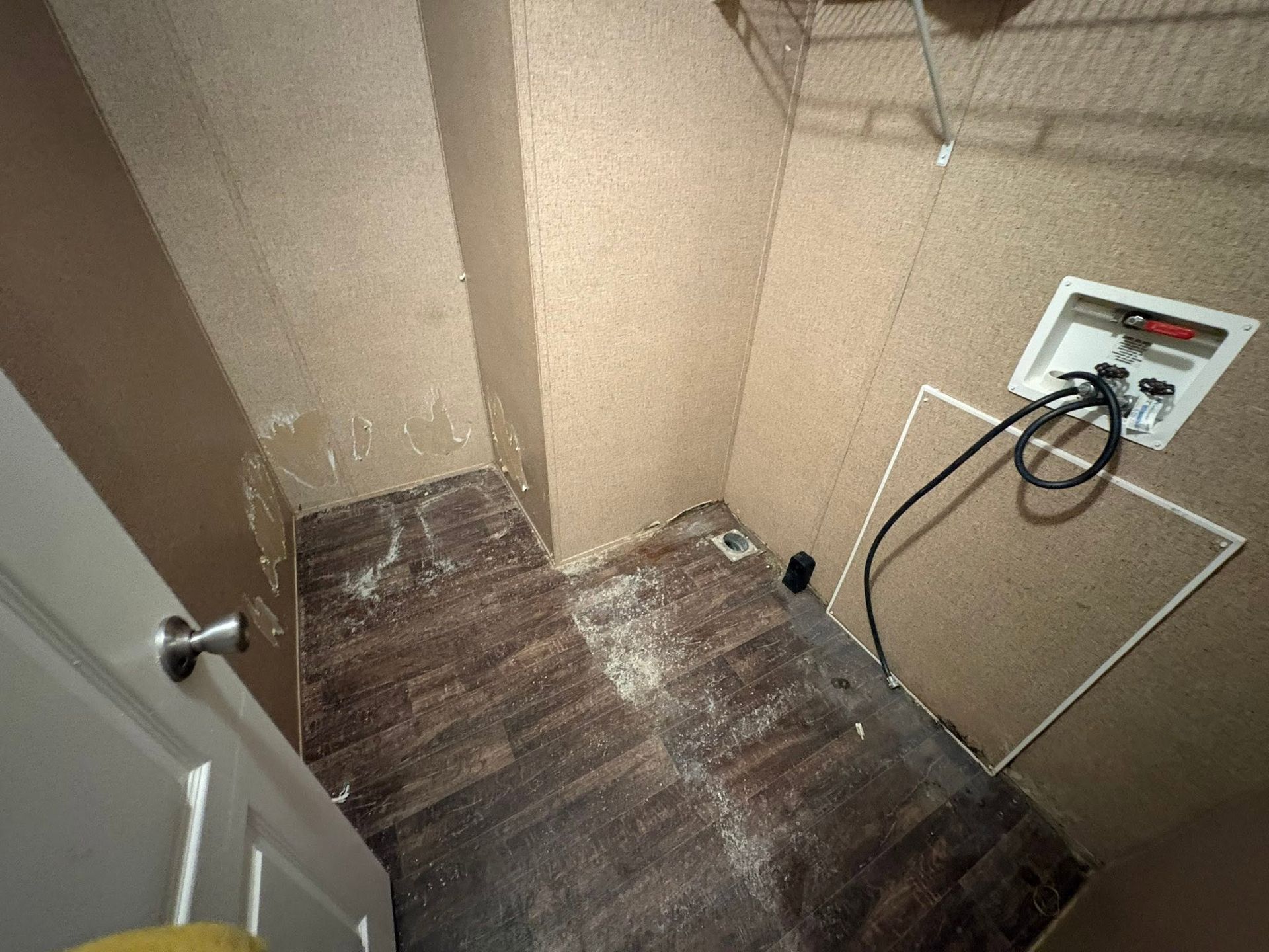 Small unfinished room with brown carpet and a wall-mounted electrical box with cables.