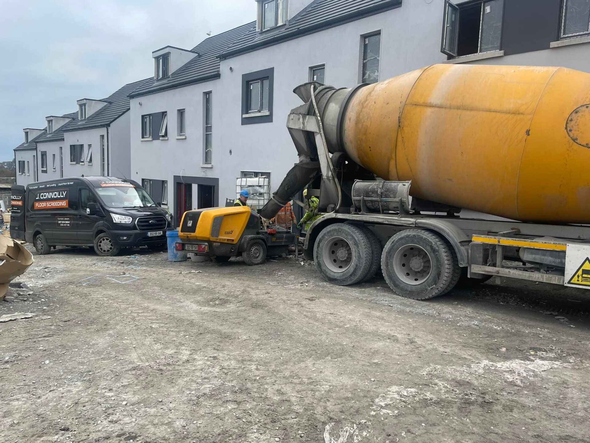A concrete mixer truck is pouring concrete on a construction site.