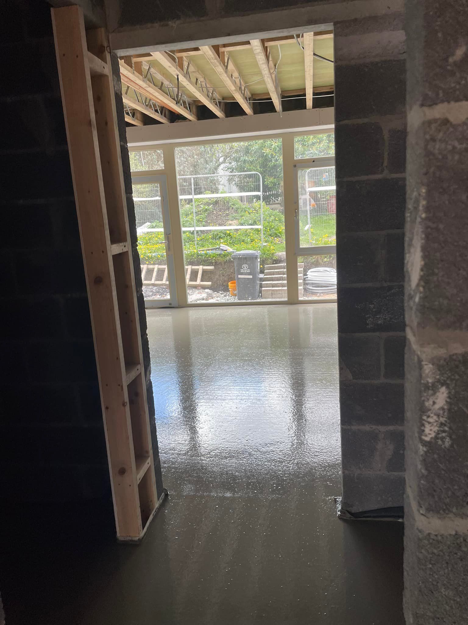 A room with a ladder in it and a large window.
